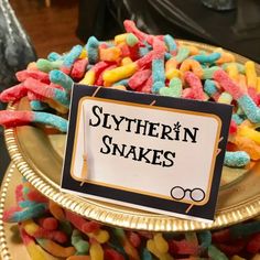 there is a sign that says slytherin snakes on top of some candy beans