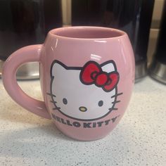 a pink hello kitty coffee mug sitting on top of a counter