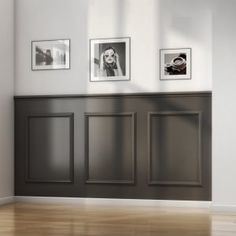 an empty room with three framed pictures on the wall and wood flooring in front of it