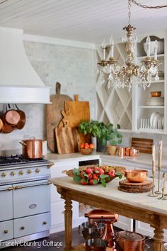 a kitchen filled with lots of appliances and counter top space under a chandelier