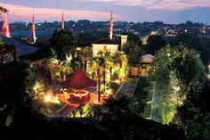 an aerial view of a city at night with lights on and trees in the foreground