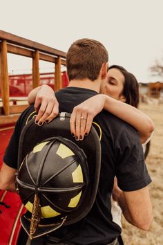 a man and woman embracing each other in front of a red truck