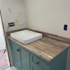 a bathroom sink sitting on top of a wooden counter