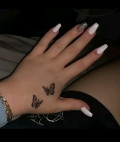 a woman's hand with butterfly tattoos on it