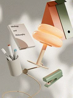 a lamp that is on top of a table next to some pens and pencils