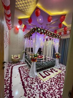 a bed decorated with flowers and balloons in the middle of a room filled with red and white decorations