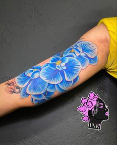 a blue flower tattoo on the arm