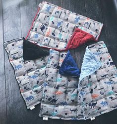 three baby bibs laying on top of each other, one with a blue and red bib