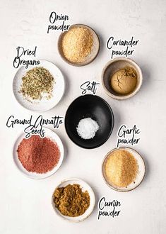 spices in bowls labeled with their names on white table top, including ground and salt