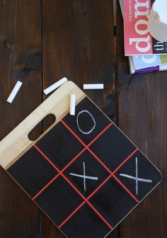 a tic - tac - toe board on a wooden table with other items