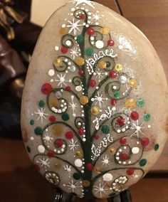 a painted rock with a christmas tree on it