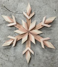 a wooden snowflake sitting on top of a cement floor