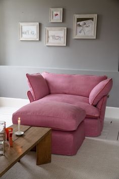 a living room with a pink couch and coffee table