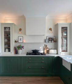 a kitchen with green cabinets and white walls