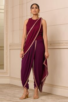 Purple, maroon dhoti-style concept jumpsuit saree in georgette with an attached drape, detailed with intricate hand-embroidered borders and features a fluted bodice.
Components: 1
Pattern: Hand Embroidered
Type Of Work: Floral
Neckline: Round
Sleeve Type: Sleeveless
Fabric: Georgette
Color: Purple, Maroon
Other Details: 
Fluted, maroon bodice
Floral borders
Pre-draped jumpsuit, dhoti silhouette
Closure: Back zipper
Occasion: Mehendi and Haldi - Aza Fashions Dhoti Jumpsuit, Dhoti Saree, Saree Women, India Style, Modern Saree, Set Saree, Saree Gown, Tarun Tahiliani, Party Wear Indian Dresses