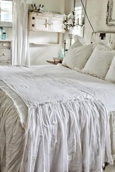 the bed is made with white linens and pillows