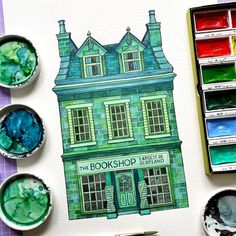 the book shop is painted with watercolors and paintbrushes next to it