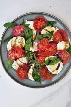 caprese salad with tomatoes, mozzarella and spinach on a plate