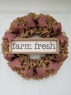 a burlock wreath with the words farm fresh hanging on it's front door