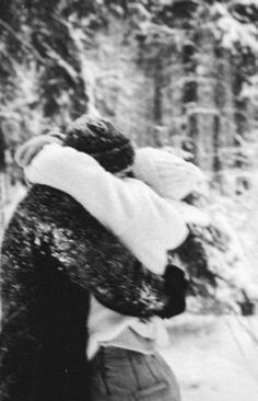 black and white photograph of two people hugging in the snow