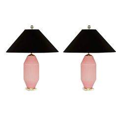 two pink lamps with black shades on them