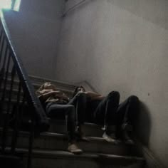 two people are laying down on the stairs