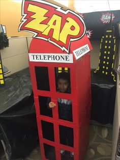 a child in a phone booth made out of cardboard