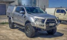 a silver pick up truck parked next to other trucks