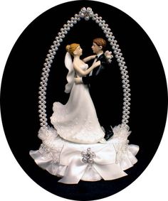 a wedding cake topper with a bride and groom on it