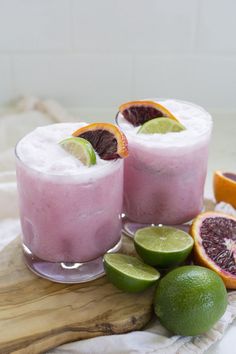 two glasses filled with pink lemonade and garnished with limes