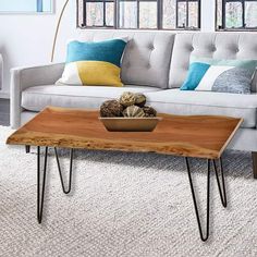 a living room with a couch, coffee table and rug on the floor in front of it