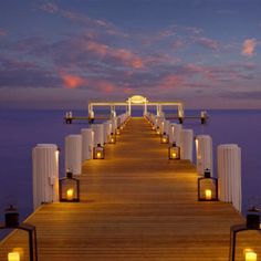 a pier with lanterns lit up at night