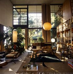 a living room filled with lots of furniture and bookshelves next to a window