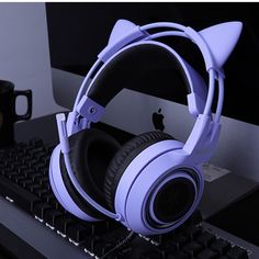 a pair of headphones sitting on top of a keyboard next to an apple computer