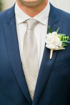 a man in a suit and tie with a boutonniere on his lapel