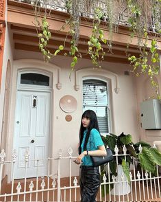 a woman is standing in front of a house