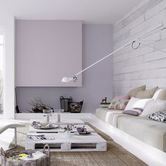 a living room filled with furniture and lots of white pillows on top of a rug