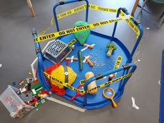 a blue play table with toys and caution tape on the floor next to it,