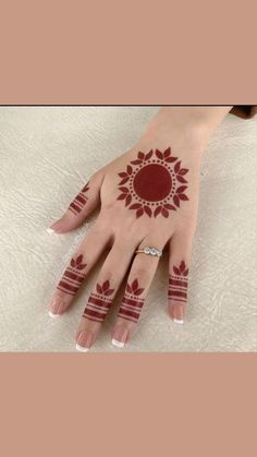 a woman's hand with hennap on it and red flowers in the middle