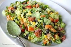 a white plate topped with a salad and a spoon