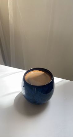 a blue bowl sitting on top of a white table