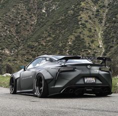 a black sports car parked in front of a mountain