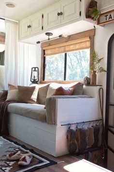 a living room filled with furniture and lots of pillows on top of the couches