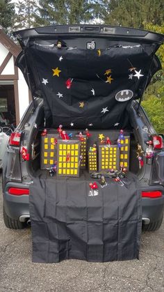 the back end of a car with its trunk open and decorations on it's hood