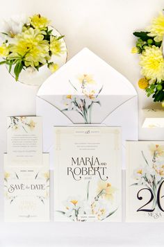 wedding stationery with yellow flowers and white envelopes on display in front of mirror