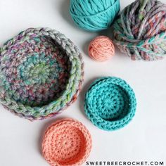 crocheted bowls and balls of yarn on a white surface