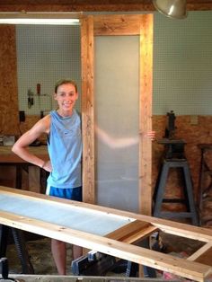 a woman standing in front of a wooden frame