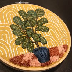 a small embroidered potted plant sitting on top of a table