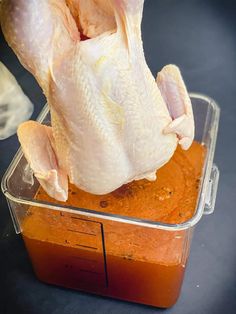 a raw chicken sitting in a plastic container