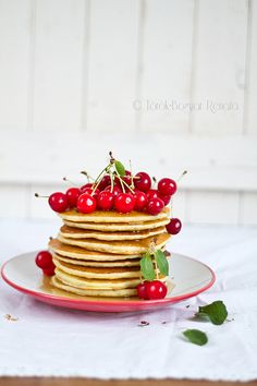 a stack of pancakes with cherries on top